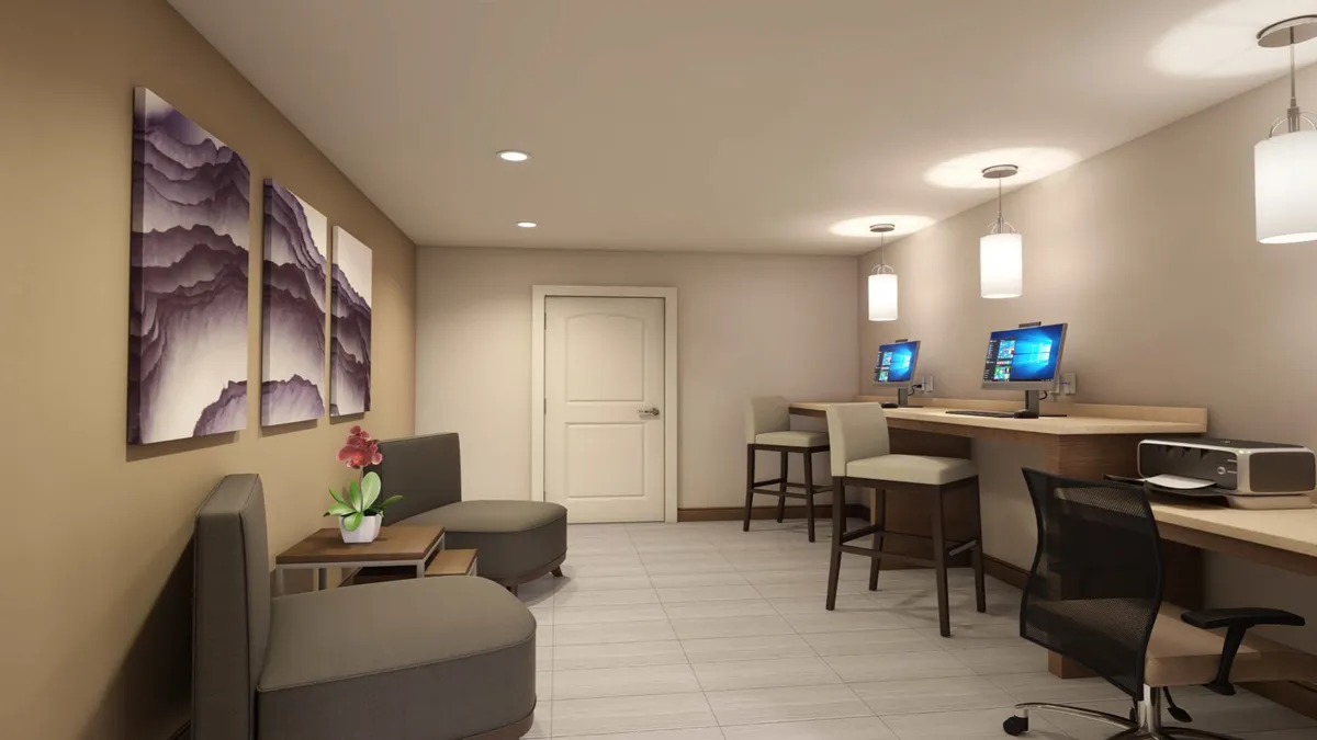 This image features a well-equipped workspace with multiple computer stations, comfortable seating areas, and modern artwork adorning the walls. The atmosphere is professional yet relaxed, ideal for both focused work and casual interactions.