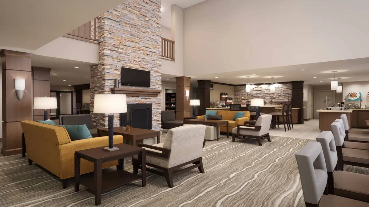 A cozy interior lounge with a stone fireplace, comfortable seating, and a bar area. The space encourages socializing over coffee or drinks and provides a relaxing environment for informal gatherings or evening socials.